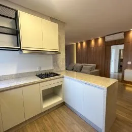 Foto de uma cozinha com armários claros e bancada em um imóvel.