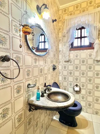 Foto de um banheiro com revestimento de papel de parede estampado e janela.