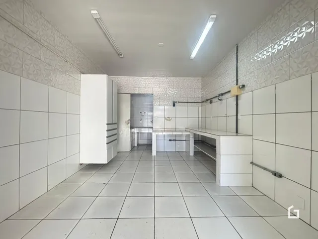 Corredor com paredes e piso de cerâmica branca.