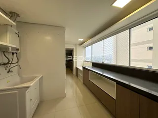 Corredor interno de um imóvel moderno com janelas amplas e revestimento de piso claro.