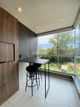 Ambiente interno com mesa de jantar e vista para o exterior.