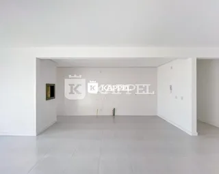 Espaço interno amplo com paredes brancas e piso claro.
