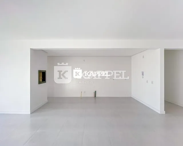 Espaço interno amplo com paredes brancas e piso claro.