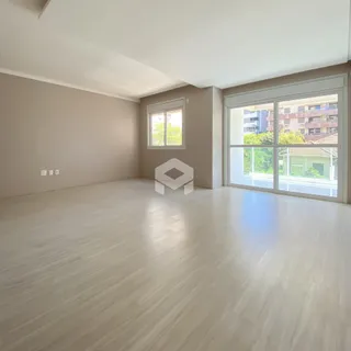 Ambiente interno de uma sala com piso de madeira clara e grandes janelas.