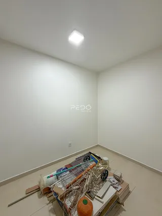 Parede branca de um cômodo com piso de cerâmica.