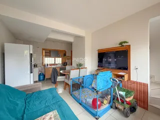 Ambiente interno de sala de estar com vista para a cozinha e área de dormir.