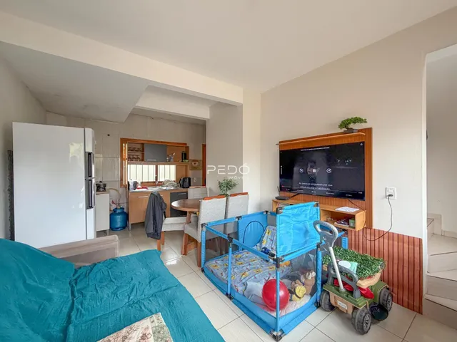 Ambiente interno de sala de estar com vista para a cozinha e área de dormir.