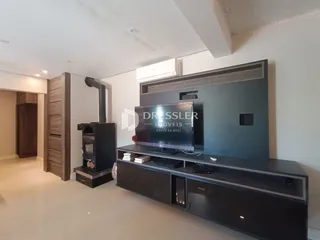 Sala de estar com móveis planejados e televisão.