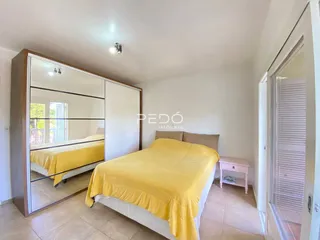 Quarto com cama e armário de parede em um imóvel.