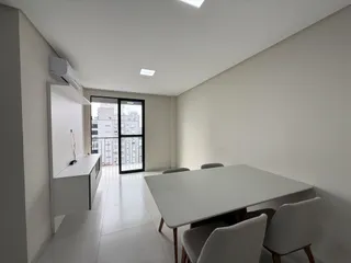 Sala de jantar moderna com mesa e cadeiras em um apartamento em Lajeado.
