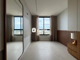 Uma sala ampla com grande janela que oferece uma vista da paisagem urbana.