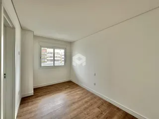 Vista interna de um ambiente com piso de madeira clara.
