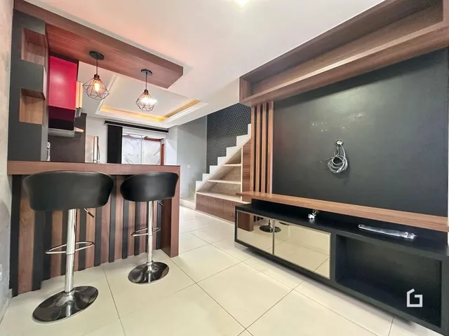 Imagem de uma sala de estar moderna com armários de madeira e escadaria.