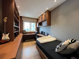 Este é um quarto com uma cama e uma área de trabalho bem iluminada.