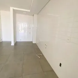Hall de corredor com paredes brancas e piso de cerâmica.