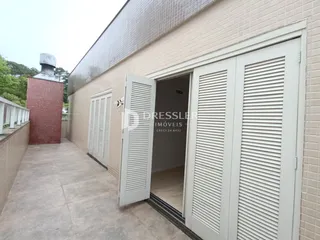 Fachada de um imóvel em Lajeado, Brasil, com paredes de tijolo e portas brancas.