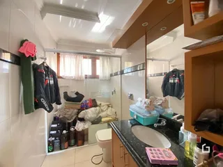 Foto interna de um banheiro com azulejos brancos e espelho.