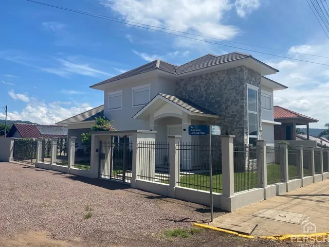 Foto da fachada de uma casa em Lajeado, Brasil, com cerca e paisagismo.