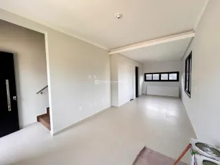 Hall de entrada com piso claro e paredes brancas em um imóvel em Lajeado.