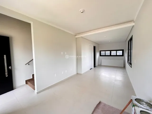 Hall de entrada com piso claro e paredes brancas em um imóvel em Lajeado.