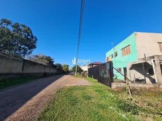 Vista da fachada de uma propriedade em Lajeado, Brasil, ao longo de uma estrada de terra.