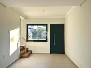 Hall de entrada com escada e janela em um imóvel.