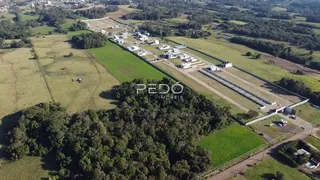 Vista aérea de uma propriedade rural com campos e estruturas no entorno.