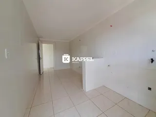 Foto de um corredor interno com paredes brancas e piso de cerâmica.