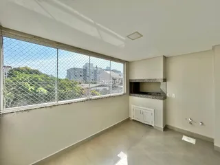 Vista da sala com grande janela e vista para a paisagem externa.