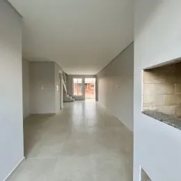Foto de um corredor interno com paredes brancas e piso claro.