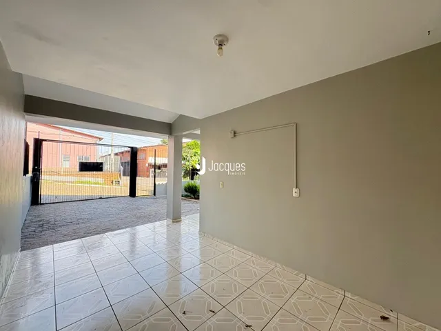 Interior de uma área que se abre para um pátio com portão.