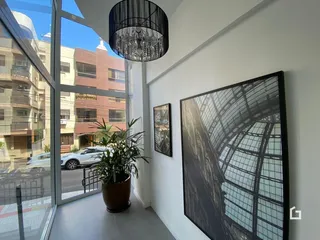 Ambiente interno com grandes janelas de vidro e decoração moderna.