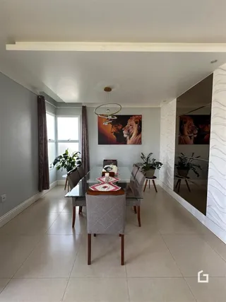 Ambiente interno com paredes claras e piso de cerâmica em uma sala de estar.