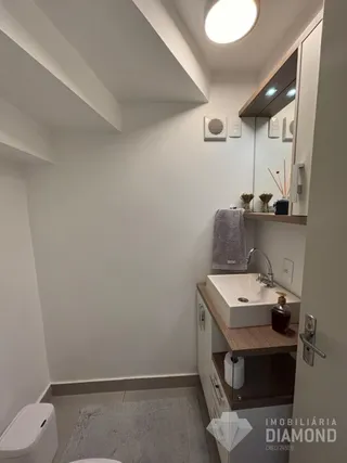 Foto de um banheiro moderno com bancada e vaso sanitário.