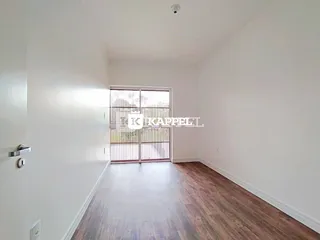 Hall de entrada com piso de madeira e porta de vidro no interior da residência.
