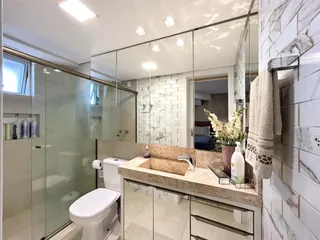Foto de um banheiro com revestimento de azulejos brancos e bancada de mármore.