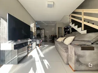 Sala de estar moderna com sofá e televisão em um apartamento.