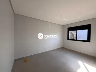 Foto de uma sala ampla com paredes brancas e piso claro.