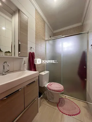 Foto de um banheiro com pia e box de vidro.