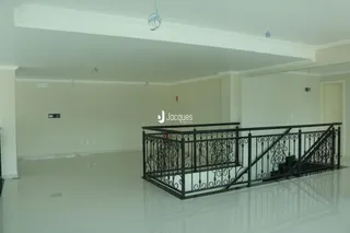 Vista interna de um ambiente com piso liso e grade de ferro preta.