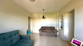 Sala de estar com sofá e piso de cerâmica clara.