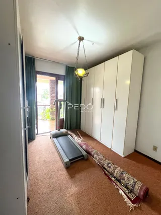 Foto de um quarto com cama e armário branco em um imóvel.