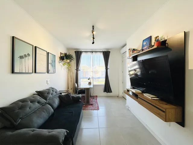 Sala de estar com sofá e televisão em um imóvel no Brasil.