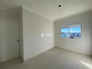 Ambiente interno de uma sala com piso de madeira clara e janela com vista.