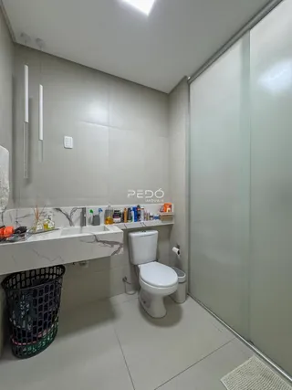Foto de um banheiro moderno com bancada de mármore e vaso sanitário branco.