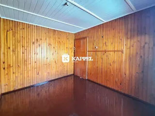 Foto interna de um ambiente com revestimento de madeira e piso polido.