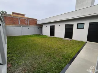 Fachada de uma casa moderna com garagem e gramado verde.