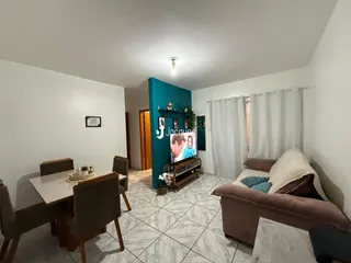 Sala de estar e jantar com sofá e mesa de jantar em um apartamento.
