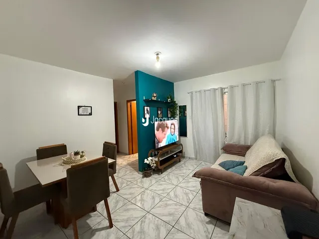 Sala de estar e jantar com sofá e mesa de jantar em um apartamento.