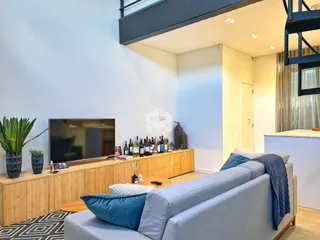 Sala de estar com sofá e televisão em um apartamento no Brasil.